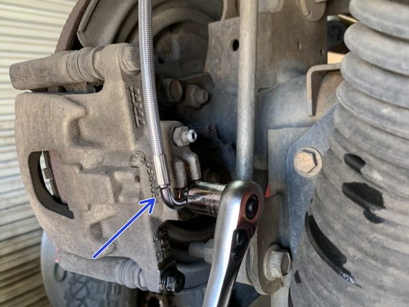 Bolt the brake line to the caliper, orient line as shown, and torque to 23 lb-ft [31 Nm].