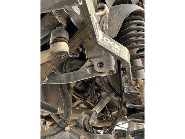 Remove the front frame side track bar bolt and nut.