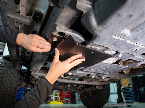 Secure the skid plate with the two frame hex bolts and the included M8 Torx flat head screw.