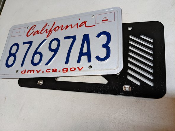 Install your license plate on the plate bracket. The cage nuts go on the bottom, as shown in the photos. Snug hardware but do not fully tighten yet.