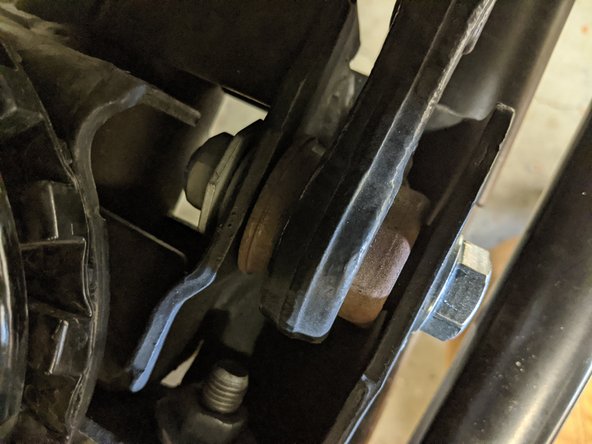 Remove the front axle side track bar bolt with a 21mm wrench/socket.