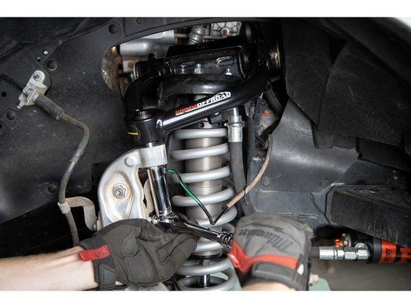 Pivot the tapered stem so that it lines up with the tapered hole in the spindle. Push the upper control arm downward so the tapered pin engages the spindle.