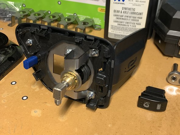 With the Base Plate lined up on the front of the Charge Port Housing, align the Bulkhead Bracket Assembly on the back.