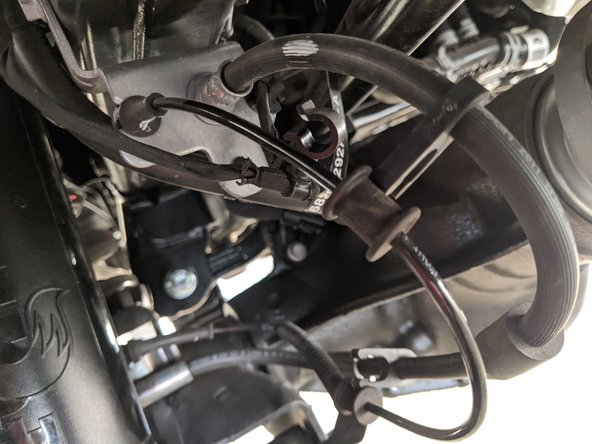 Unclip the wire loom attached to the brake line by the frame.
