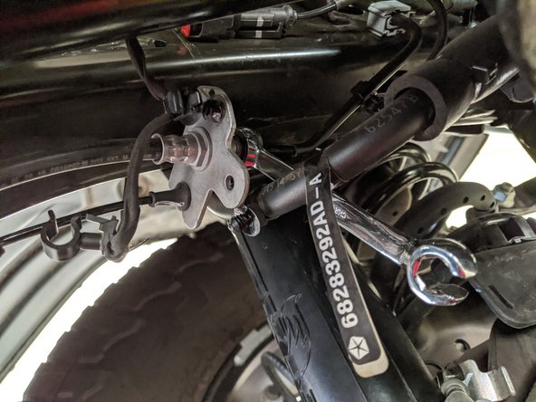 Loosen the frame-side hard line fitting with a 12mm flare nut wrench.