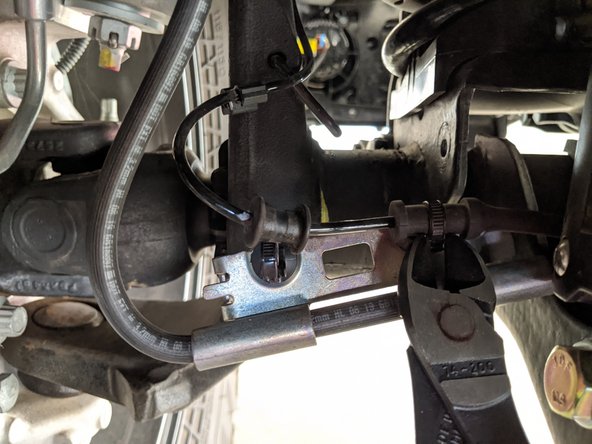 Slide the axle bracket out towards the wheel and using dyke cutters, cut the two zip ties securing the wheel speed sensor to the bracket.