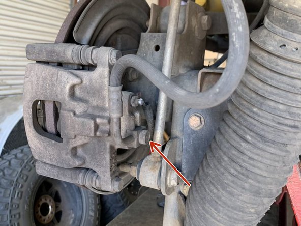 Remove the banjo bolt at the brake caliper with a 15mm wrench/socket. As soon as the bolt is loosened fluid will start leaking. Make sure to have a drain pan ready before loosening the bolt.
