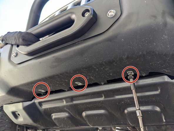 Using a T45 torx driver, remove the three bolts in the center of the bumper securing the skid plate.