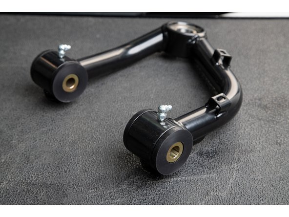 Apply grease to the inside and outside of the Hat Bushings, and slide them into the upper control arm pivot tubes.