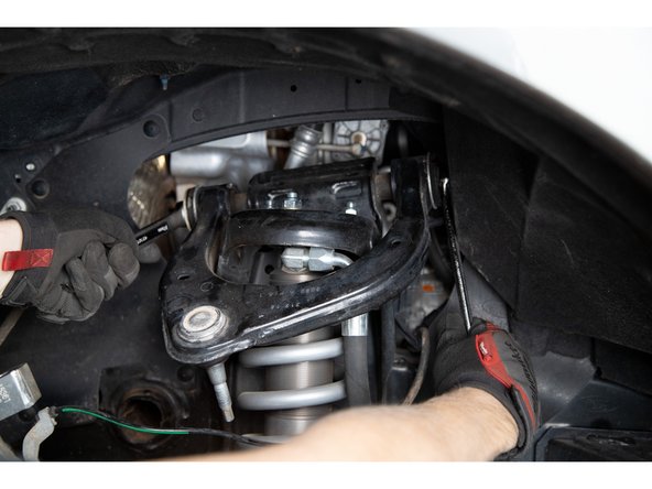 Slide the pivot bolt out from the back of the upper control arm.