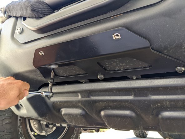 Place mounting bracket against the skid plate and bumper as shown, and re-install the factory hardware.