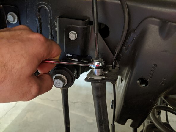 Loosen the frame-side hard line fitting with a 12mm flare nut wrench and a 16mm open end wrench. Remove the factory brake line.