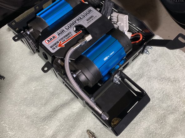 Install the 1/4” NPT x JIC4 90° fitting into the ARB compressor manifold cap using a 9/16&quot; open end wrench. Make sure to use thread sealant on the NPT thread and orient the fitting as shown.