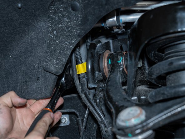 Using a 21mm socket/wrench, loosen the upper control arm bolts. Just loosen, do not remove.