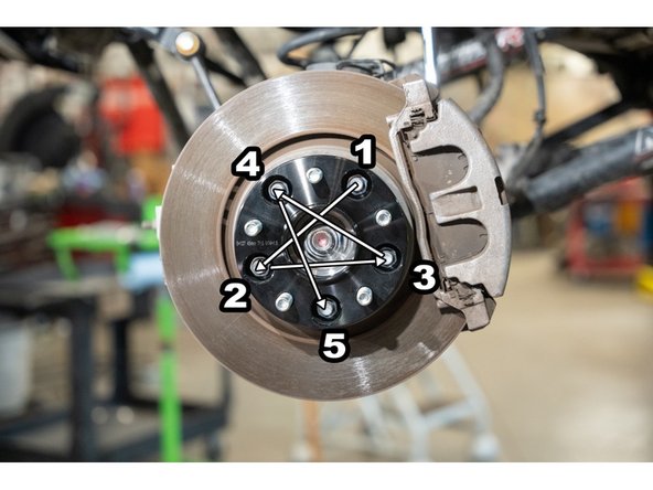 Tighten the lug nuts in a star pattern as shown to ensure even tightening. A pry bar can be used to prevent the wheel spacer from spinning.