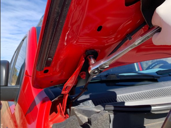 Slide the light bracket onto the hood studs and then lightly tighten the nuts.