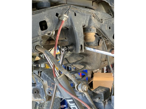 Remove the rear frame side track bar bolt and nut.