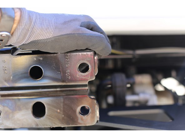 Insert a bumper mount support between the frame and the Grimm Winch Plate and install an M10x1.5 x 35mm bolt. Repeat on other side of frame.