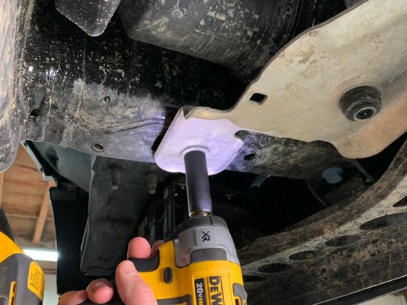 *If equipped* Using a 15mm wrench/socket, remove the two bolts securing the silver lower intercooler mount to the underside of the frame.