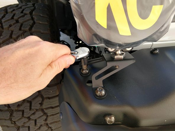 Place the light mount on top of the holes and then re-install the factory bolts.