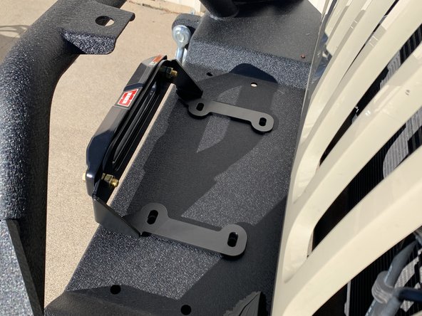 Set the Fairlead Mounting Plate over the appropriate mounting holes in the bumper.