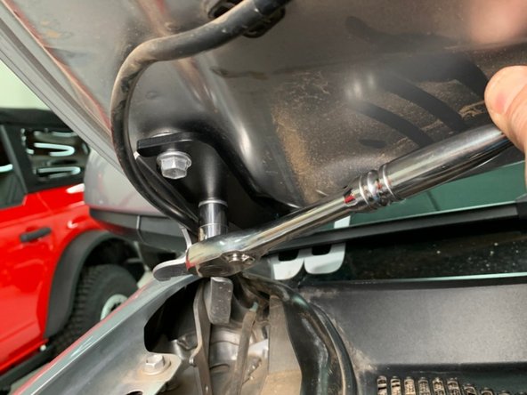 Slide the light bracket onto the hood bolts and then lightly tighten the bolts.