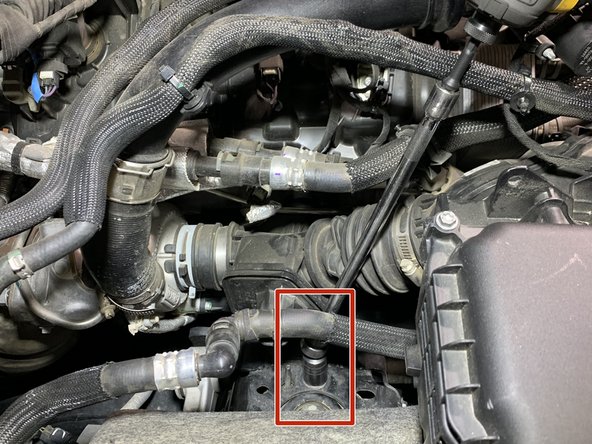 Using a 15mm socket, remove the upper shock tower mounting nut and install the support bracket as shown using factory flange nut.