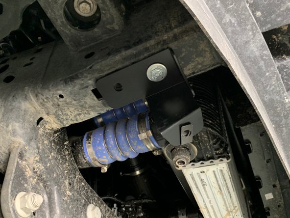 Attach the Engine Skid Brackets to the frame as shown using provided bolts and washers in the forward mounting hole. The skid mounting flanges should be oriented towards the front of the vehicle and in towards the center.