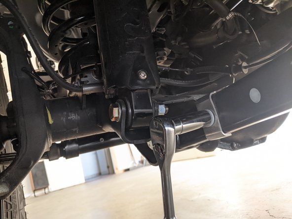 Use a 15mm wrench/socket to unbolt the brake line bracket from the lower control arm.