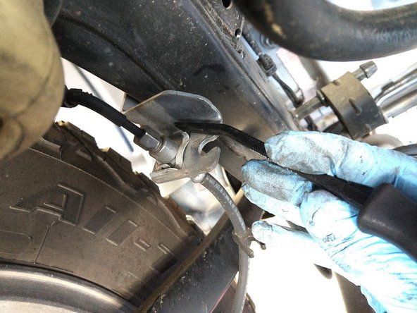 Remove the clip securing the brake line to the frame side bracket with a pry bar or flat head screwdriver.