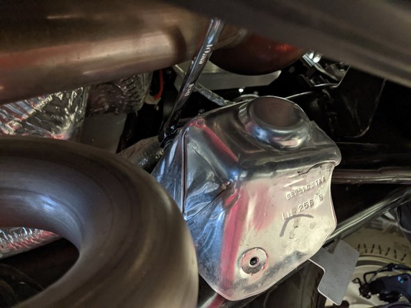 Remove the two screws holding on the heat shield with a 10mm wrench/socket and remove the heat shield.