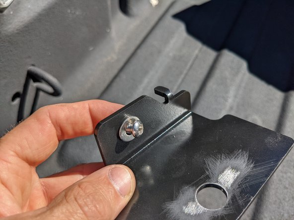 Place the washer under the bolt head and through the bracket as shown, install in bed.