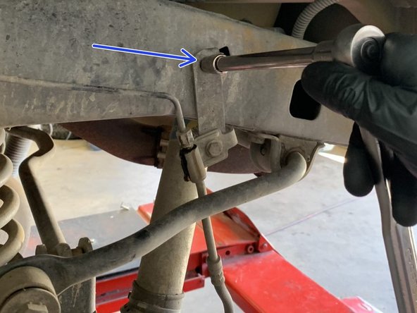 Remove the hard line nut from the factory brake line bracket where it mounts to the frame using a 12mm flare nut wrench. As soon as the nut is loosened, brake fluid will start leaking. Make sure to have a drain pan in place before loosening the nut.