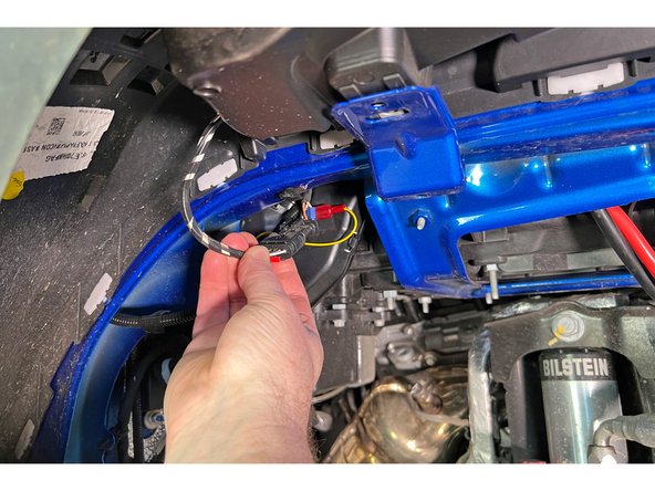 Detach the fender flare wiring connector from its mount.