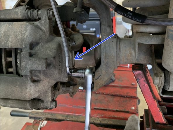 Bolt the brake line to the caliper, orient line as shown, and torque to 23 lb-ft [31 Nm].