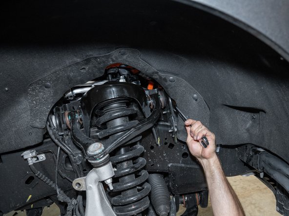 Using a 21mm socket/wrench, loosen the upper control arm bolts. Just loosen, do not remove.