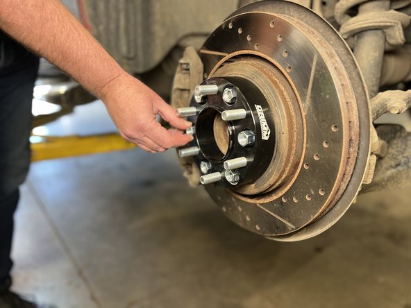 Thread on the provided lug nuts onto the wheel studs. (Make sure red thread locker has been applied to the wheel studs first!)