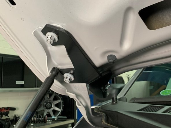 There is a left and right hood hinge light bracket. Make sure you have the correct bracket for the side you are installing. The brackets install from the center of the vehicle out, with the slots sliding over the hood studs as shown.
