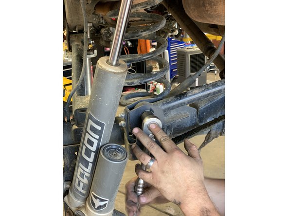 Remove the rear axle side track bar bolt and flag nut.