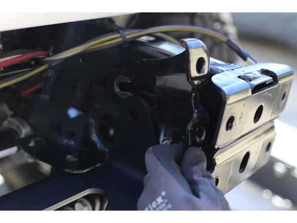 Remove the upper bolt that was temporarily installed to hold the Winch Plate in place.