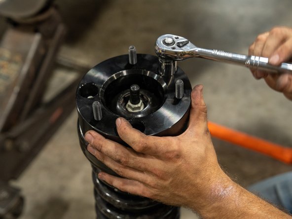 Next, bolt the Grimm OffRoad spacers to the factory strut assemblies using the provided washers and nylock nuts.