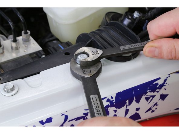 Hold the large nut with a 17mm wrench and tighten the bolt using a 13mm wrench. Continue to tighten until the rivet nut crushes and is tight in place, then remove the bolt.