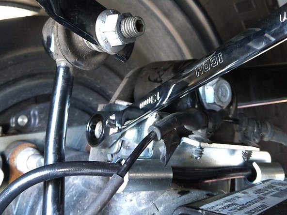 Using a 13mm wrench/socket torque the axle side brake line retention bracket bolt to 8 lb-ft [11 Nm]