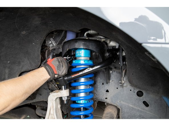 Grease the zerk fittings until grease is visibly coming out of the bushings and then tighten the pivot bolt using a 21mm socket/wrench.