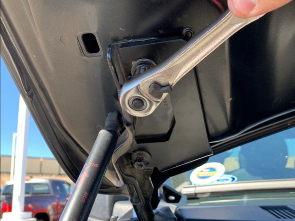 Slide the light bracket onto the hood studs and then lightly tighten the nuts.