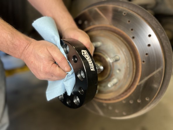 Clean the wheel spacer mounting surface with a clean shop towel.