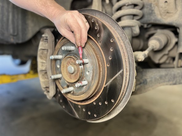 Apply the provided high strength thread locker to the wheel studs on the axle.