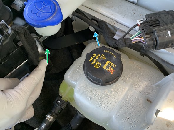 Remove the factory 6mm bolt between the windshield washer reservoir and coolant overflow tank using a 10mm socket/wrench.