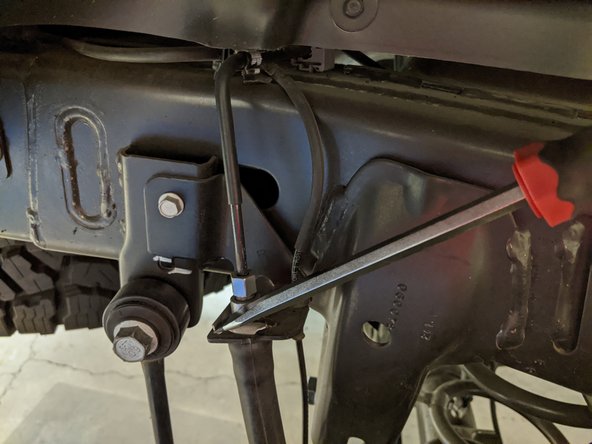 Pop the brake line securing clip off the frameiside bracket with a flat head screw driver or punch and a small hammer.