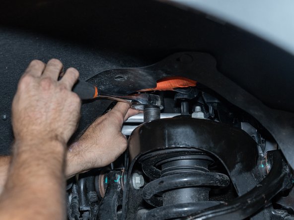 Remove the nuts from the upper strut mounting studs with an 18mm socket/wrench.